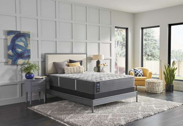 Well-made mattress in a bedroom with gray walls