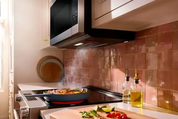 The KitchenAid KMMS130RPS microwave venting smoke from a cooking pan 