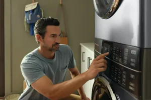 A man selecting a cycle on the Electrolux ELTE7600AW laundry tower