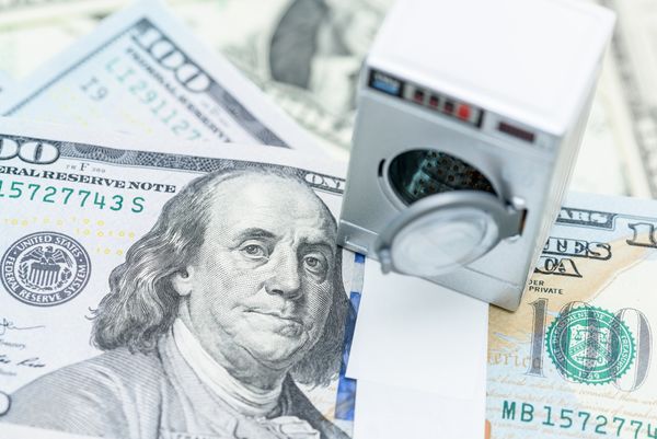 An overhead view of a mini washer on $100 bills