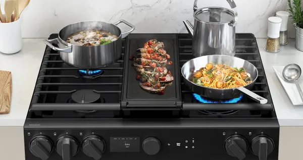A close-up of items cooking on the Samsung NSG6DG8700SR slide-in range
