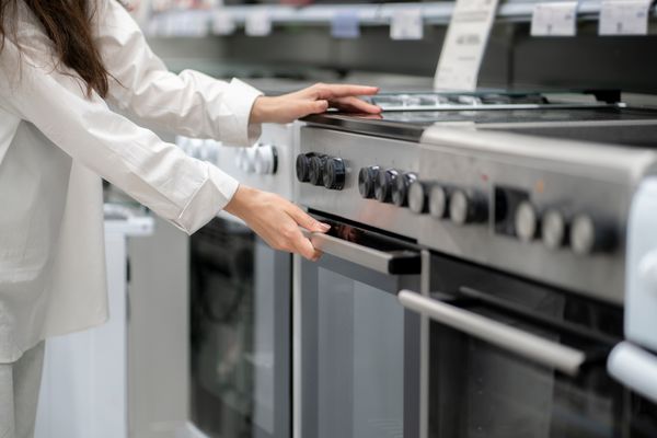 A person reviewing an electric range in a store