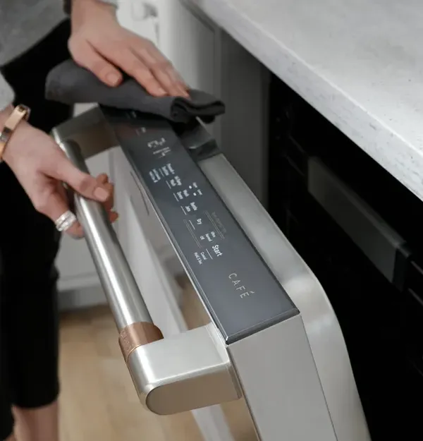 A close-up of a person opening a Café dishwasher 