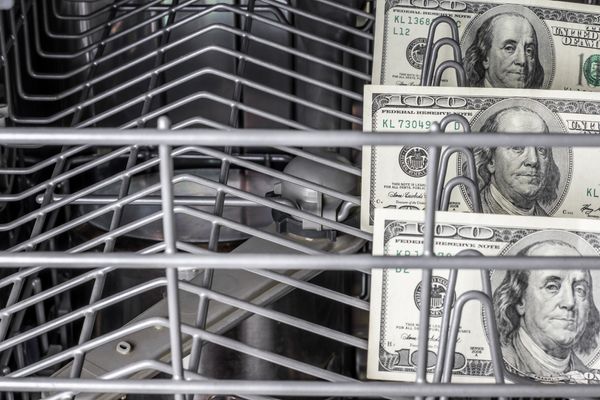 Several $100 bills inside of a dishwashing machine 