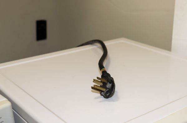 A dryer plug on top of a dryer 