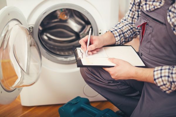 A person conducting a check on a washer