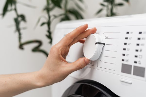 A person selecting a cycle on a front load washer