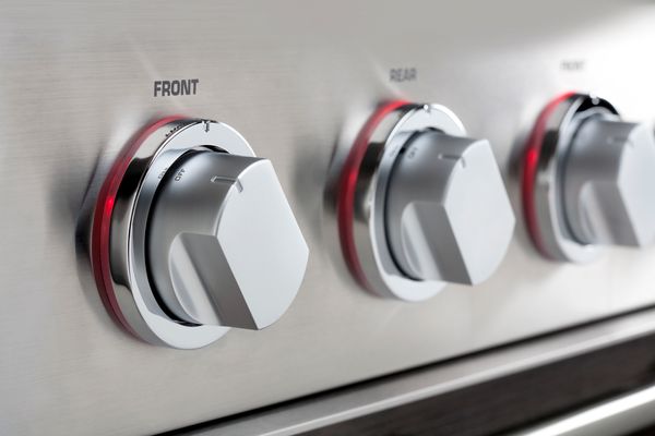 A close-up of knobs on a stove 