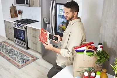 A man using the LG Scan to Cook feature on a frozen dinner 