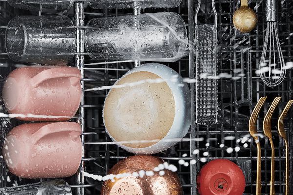 An overhead view of dishes cleaning inside of a KitchenAid dishwasher