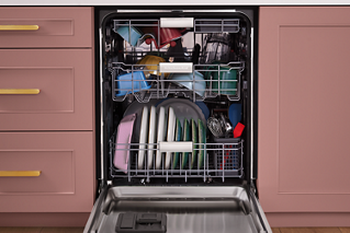 Front view of an open KitchenAid dishwasher full of dishes