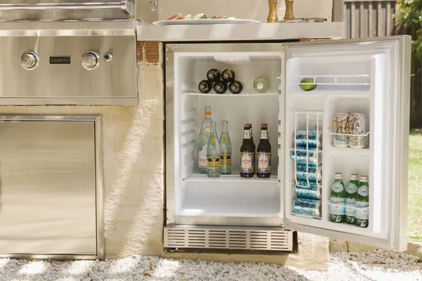 The Coyote CBIR-L outdoor refrigerator featured in an outdoor bar station