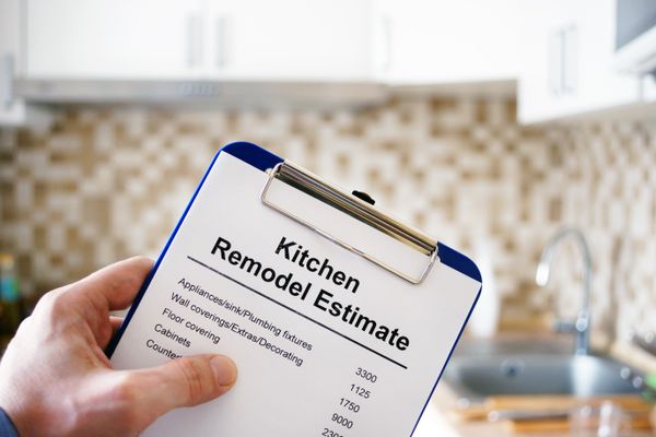 A person holding a clipboard with kitchen remodel estimates 
