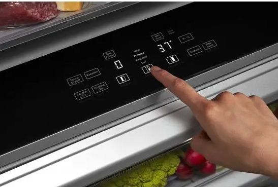 A person selecting a temperature setting on the KitchenAid KBSN708MBS refrigerator pantry drawer