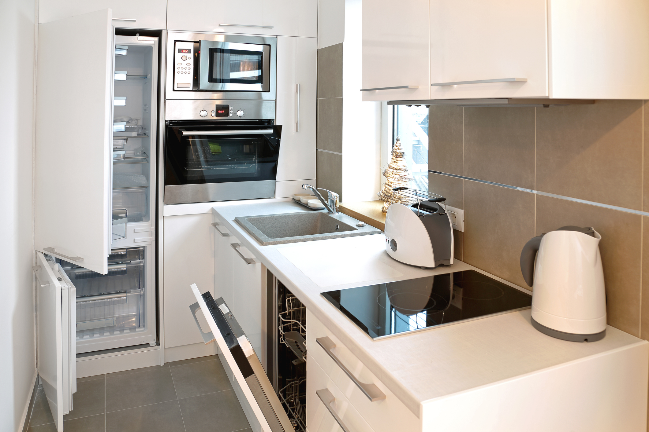 all white small kitchen with open appliances