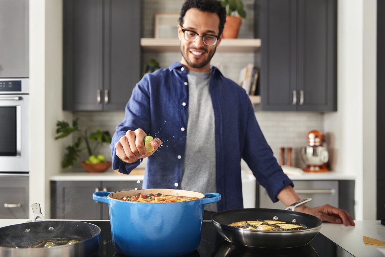 A man cooking on the KitchenAid kcig556jss cooktop 