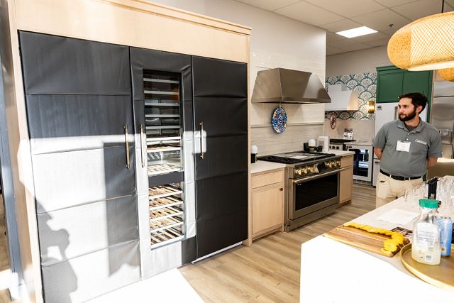 Credit: Ken Black Productions Front view of a Gerhard's team member standing in front of an appliance display in store