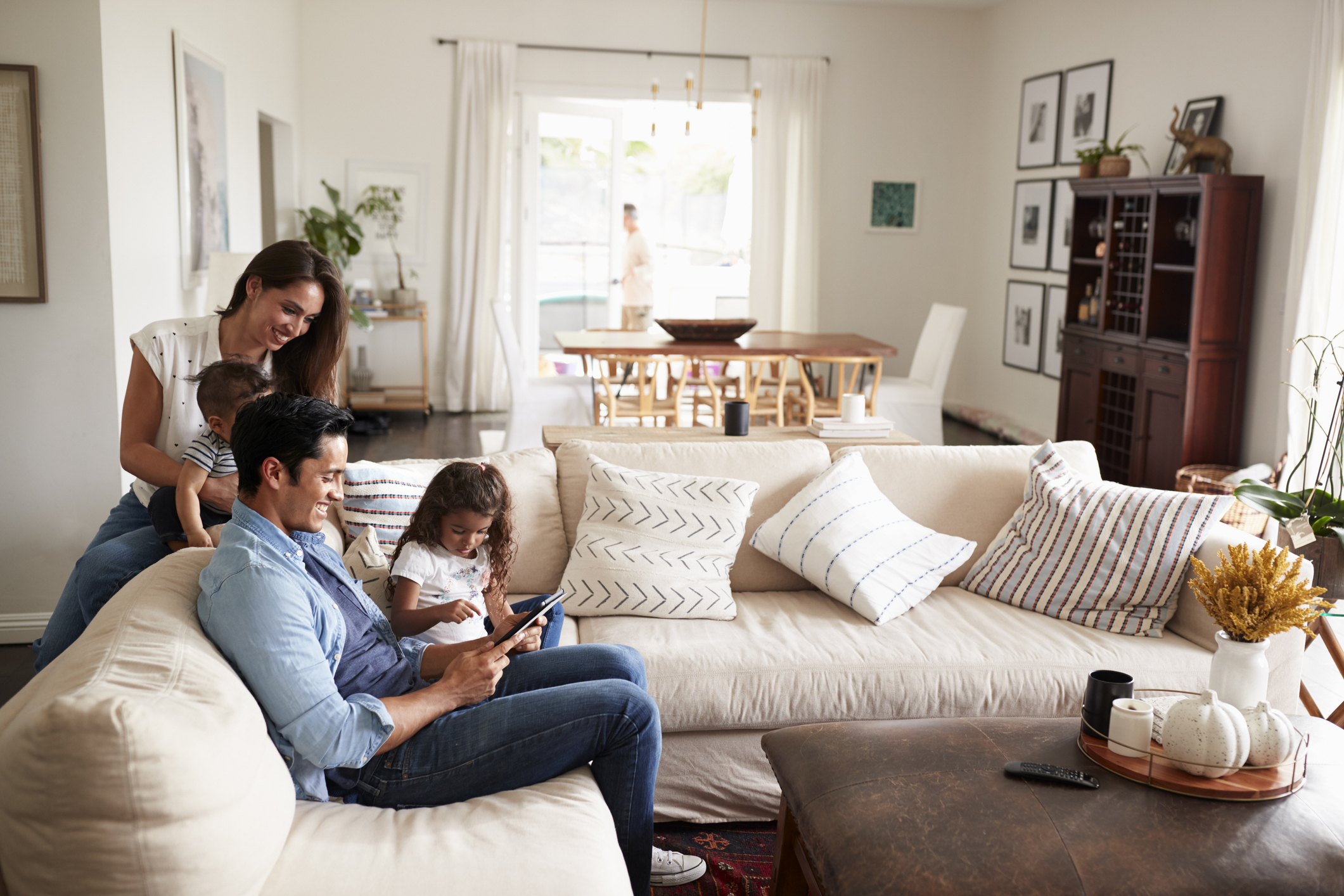 Young family sitting on a sofa shopping online together