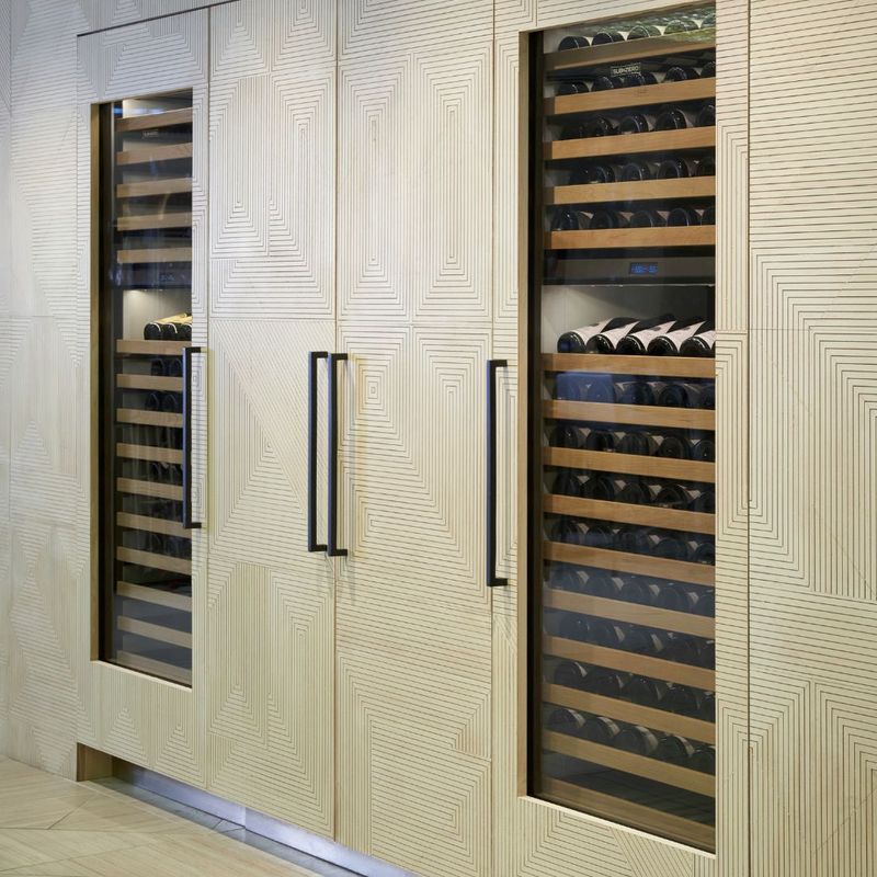 Column wine refrigerators in a light wood panelling