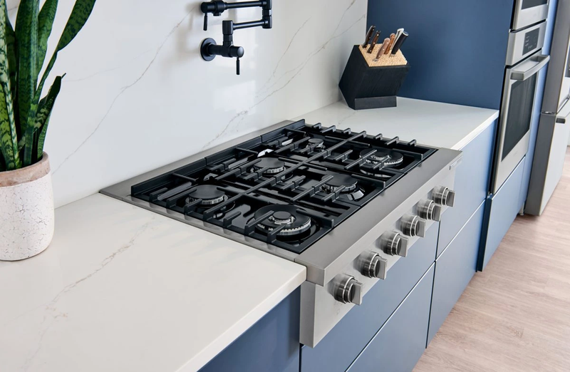 Built-in rangetop and oven in a kitchen with blue cabinets