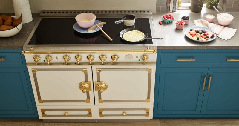 Cream colored electric stove and blue cabinets