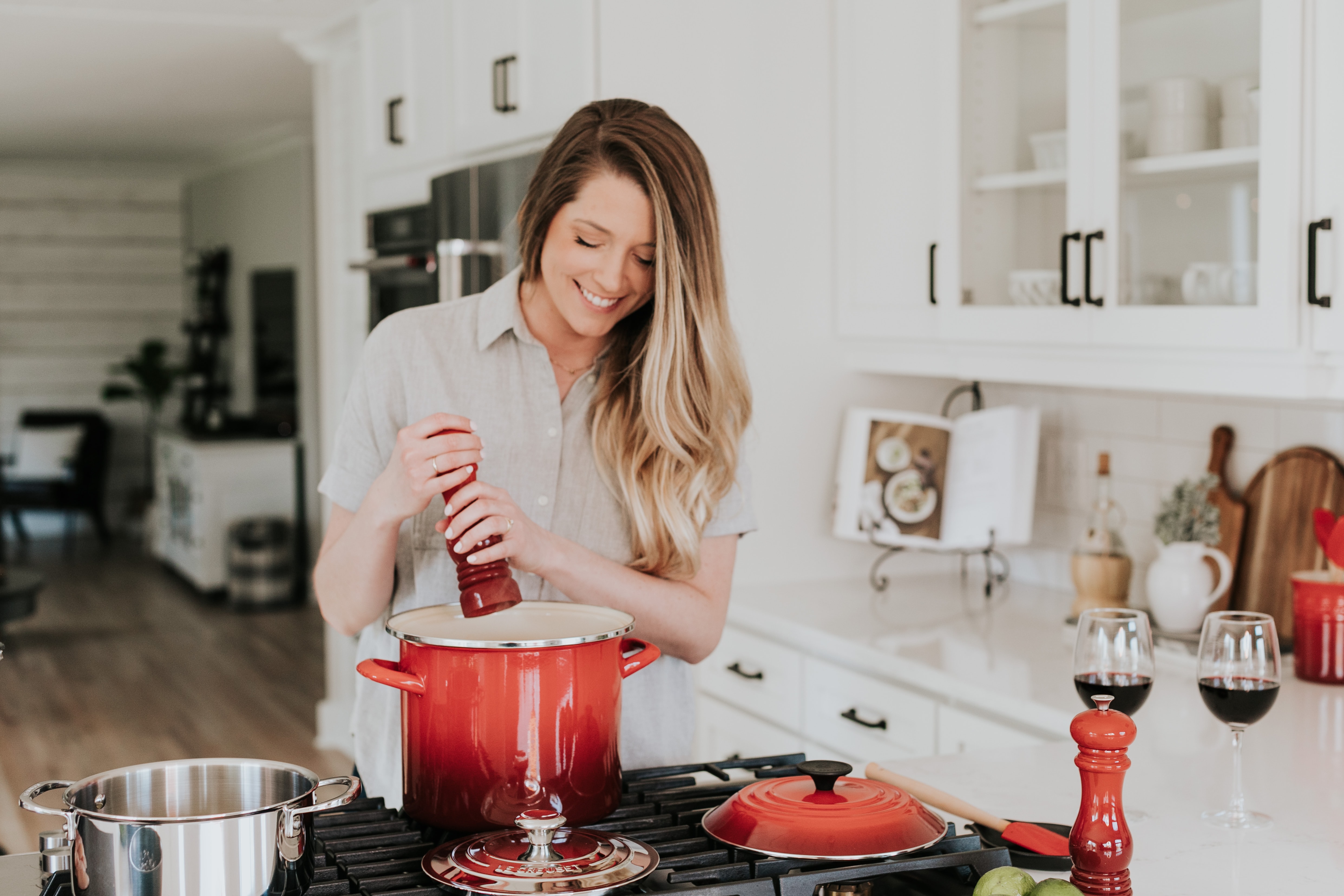 Smiling woman puts pepper in a pot