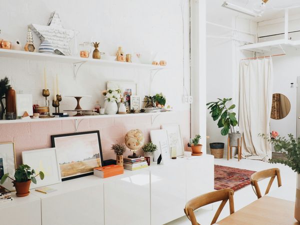 White wooden shelves playfully decorated with candle sticks, ceramics, books, and more