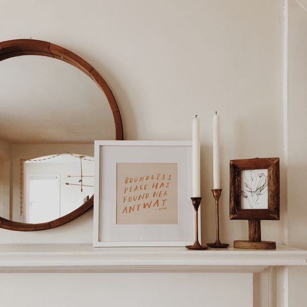 A mantle with carefully arranged candles and decorative accents
