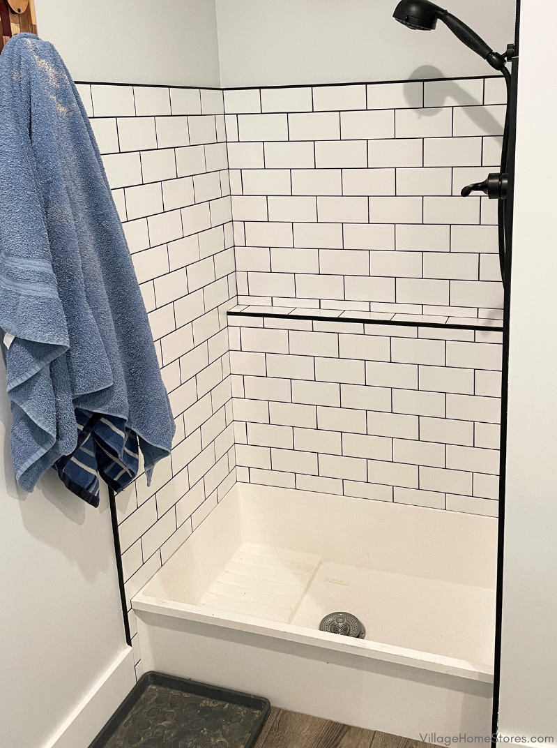White shallow shower base with subway tiled walls for dog wash shower station. 