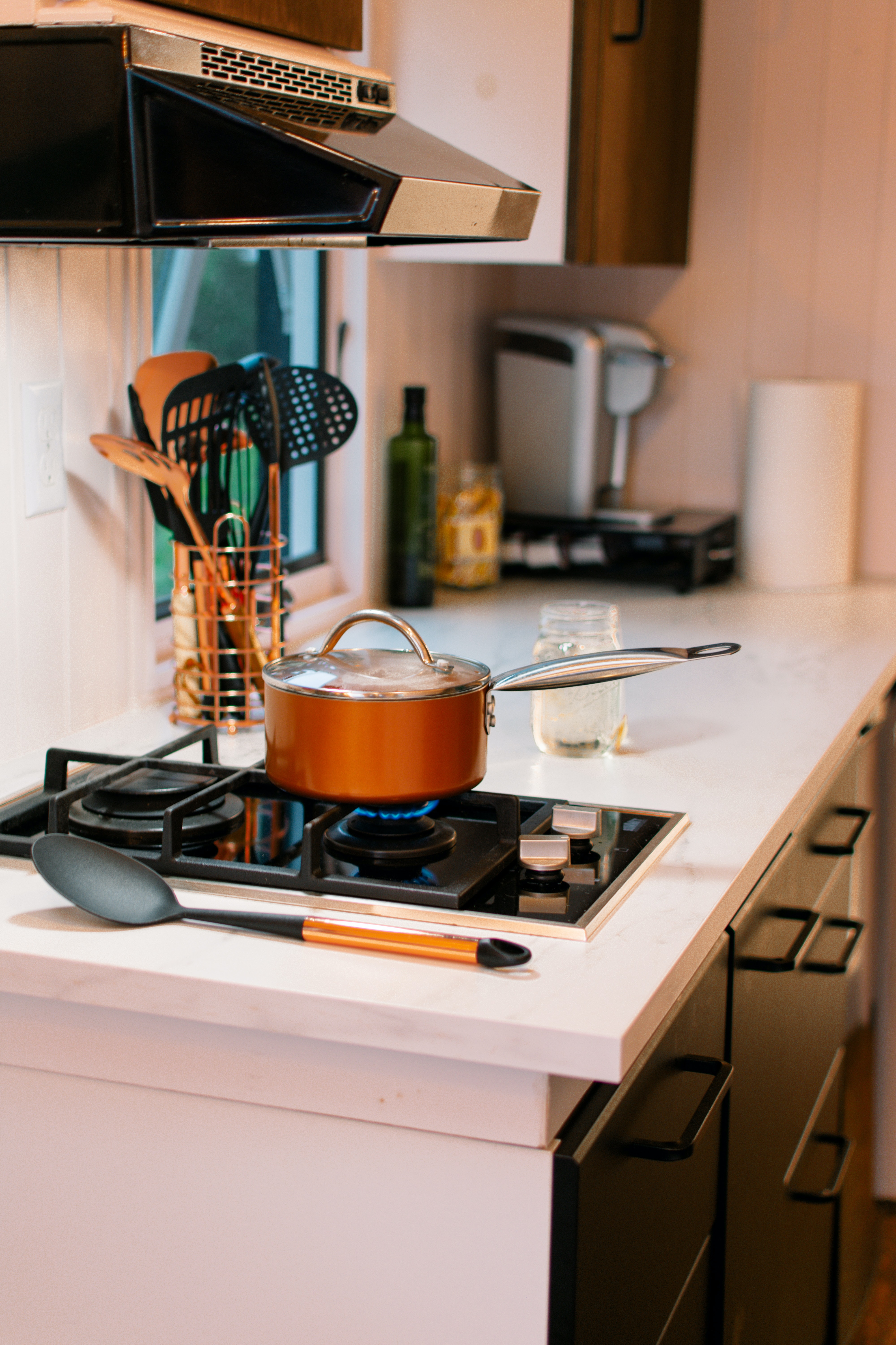 A 2 burner gas grill cooktop with a copper pot 