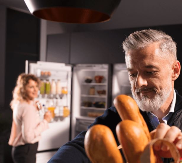 man and woman putting away groceries