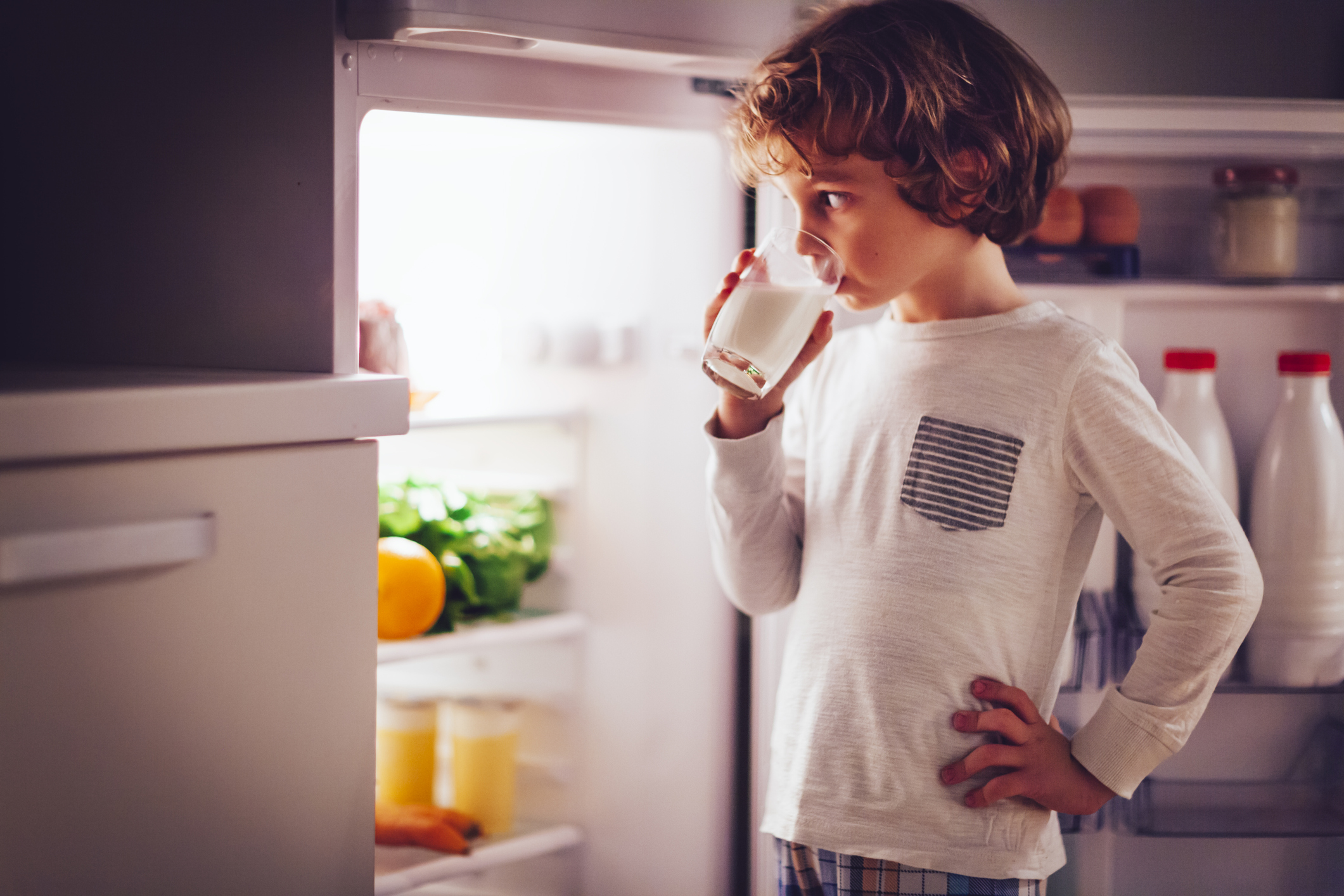 little boy drinking a glass of milk