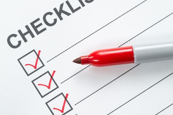 A close-up of a checklist with a red marker 