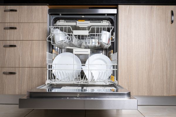 An open dishwasher full of dishes 