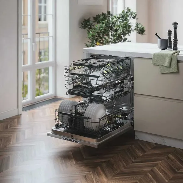 The ASKO DBI564ISSOF dishwasher open with a full load of dishes 