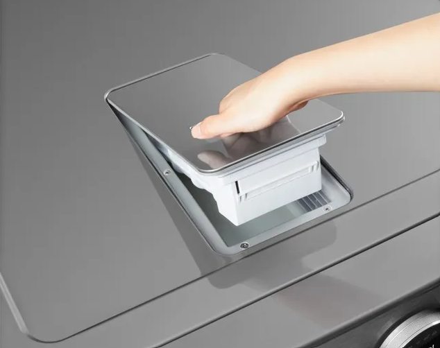 Close view of a person opening the filter on an LG washer dryer combo