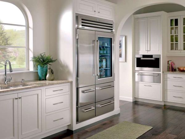 Built-in glass door refrigerator in a kitchen with white cabinets