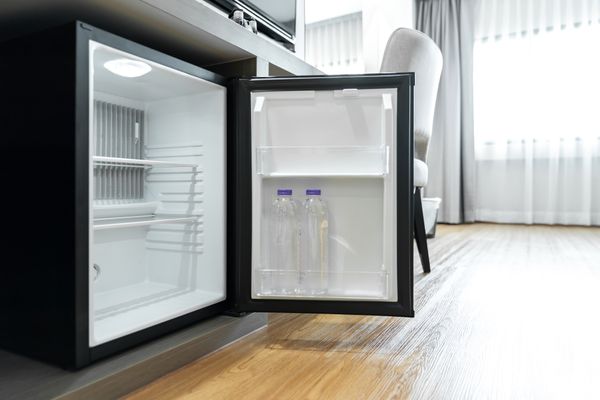 An open black beverage refrigerator in a bedroom 