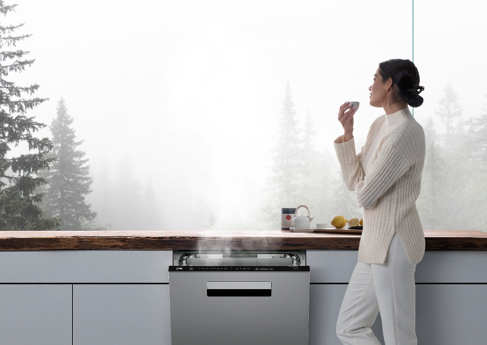 A woman stands before her window next to a Beko dishwasher