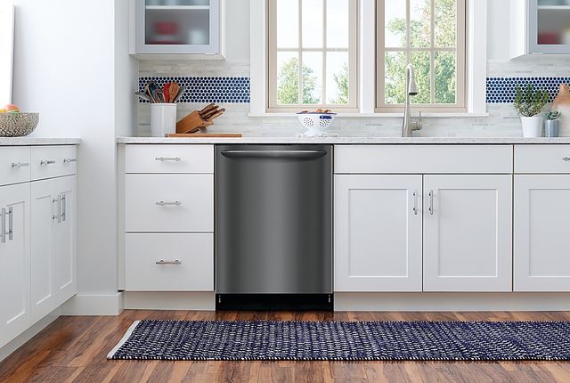 front view of a black stainless steel dishwasher built into white cabinetry in a modern kitchen