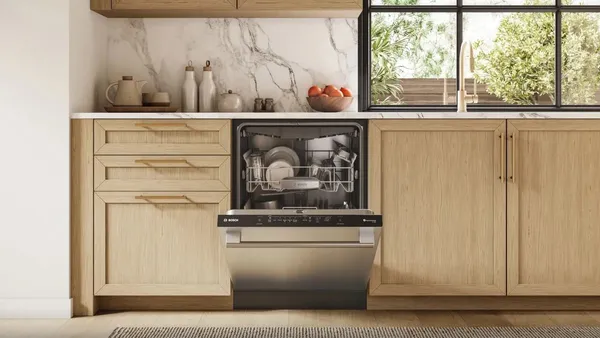 An open Bosch 500 Series SHX65DM5N dishwasher in a kitchen