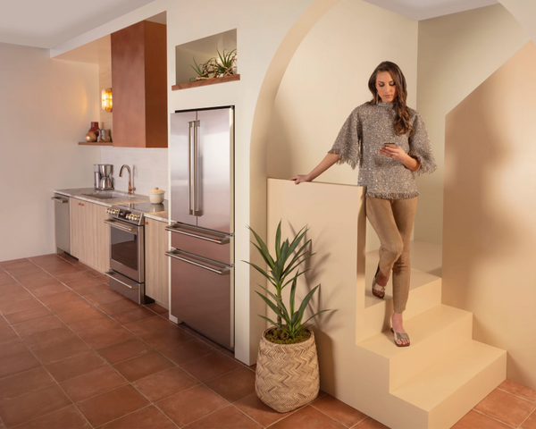 Credit: Cafe A woman in a kitchen featuring the Cafe CJE23DP2WS1 refrigerator