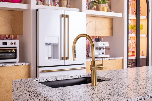 A matte white Cafe refrigerator with brushed brass hardware 