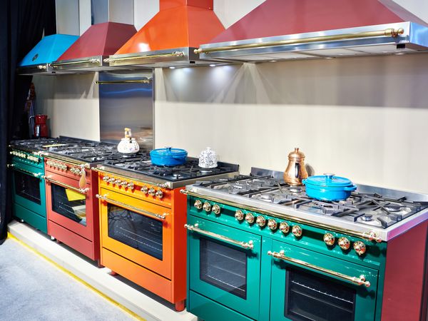 A variety of colorful ranges and range hoods on display in a store 
