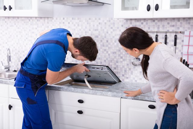 View of a professional installing a cooktop in a modern kitchen 