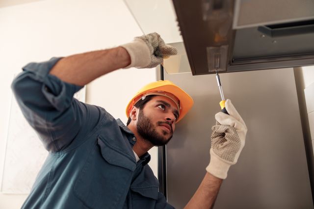 front view of a man completing a range hood installation