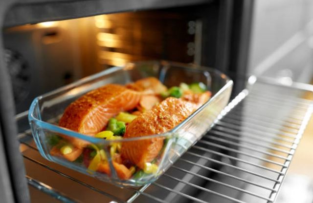 close view of a dish of fish and veggies cooking in a steam oven