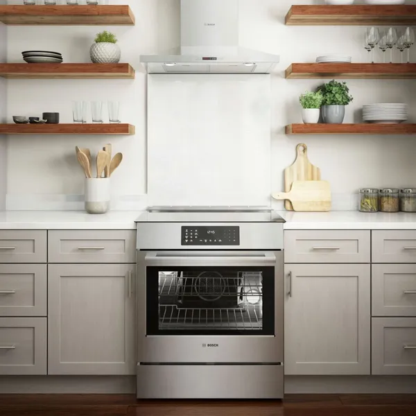 Bosch Benchmark induction range installed in a kitchen beneath a Bosch wall mounted Range hood