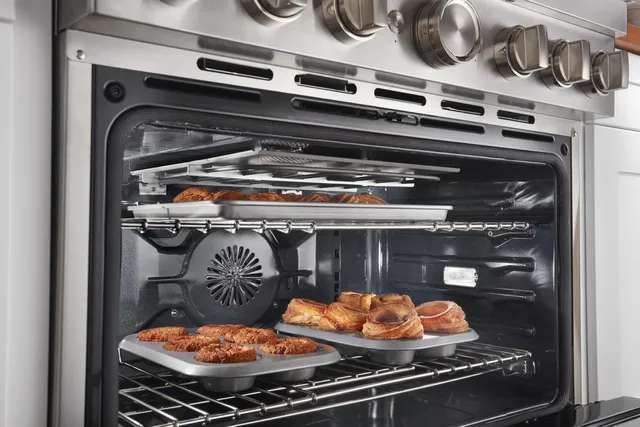 front left view of the inside of a dual fuel oven with pastries baking inside