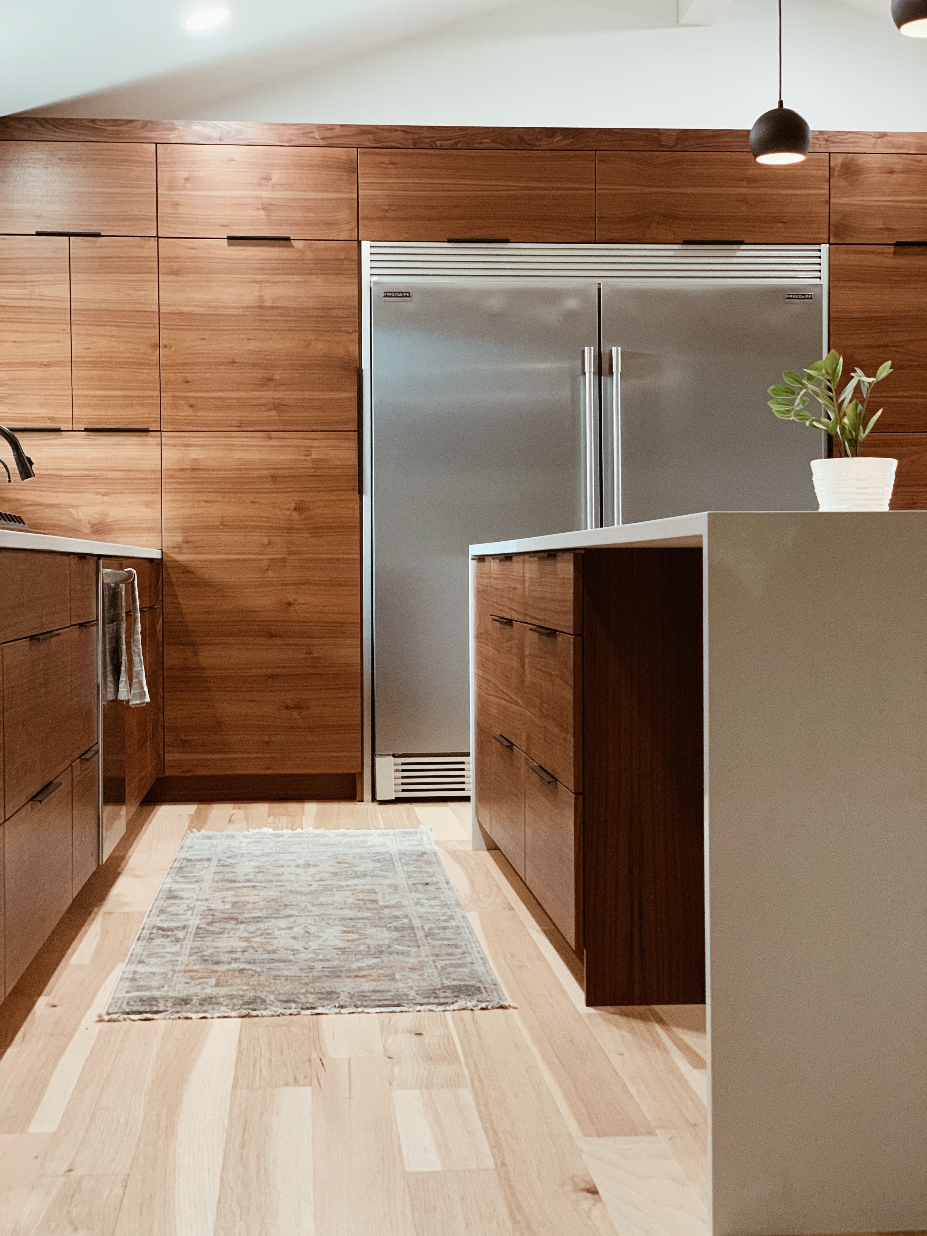 Counter depth stainless steel refrigerator in a mid century modern kitchen